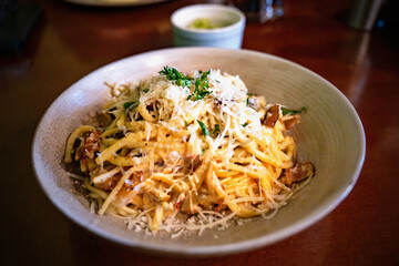 Spaghetti carbonara with bacon and grated cheese, herb.