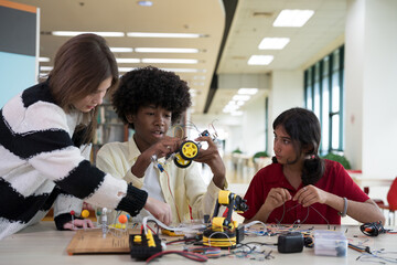 Group of students learning to assemble robots in library room at school. Robotics academy room. Technology and scientist at school concept