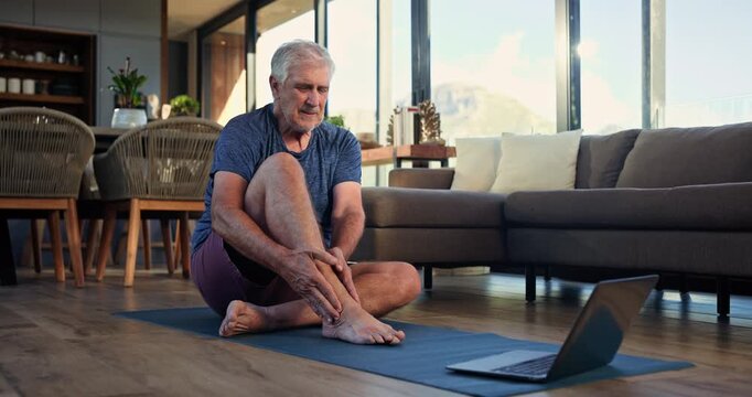 Old man, pain and legs with laptop, exercise mat and talk in living room with injury at home. Senior person, fatigue and burnout with muscle ache, inflammation or computer for virtual fitness class