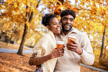 African American Couple Walking with Coffee in Autumn Park