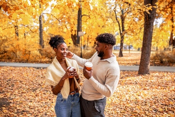 African American Couple Walking with Coffee in Autumn Park