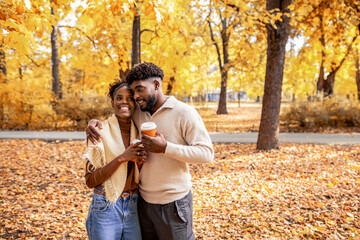 African American Couple Walking with Coffee in Autumn Park