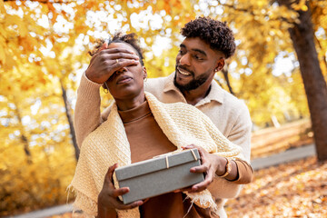 Couple Sharing a Sweet Surprise in Autumn Park