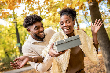 Couple Sharing a Sweet Surprise in Autumn Park