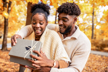 Couple Sharing a Sweet Surprise in Autumn Park