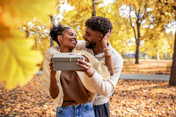 Couple Sharing a Sweet Surprise in Autumn Park