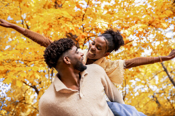 Happy African American Couple Enjoying Piggyback Ride in Autumn Park