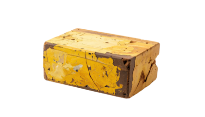 Aged, rectangular block with faded yellow paint and exposed, cracked edges