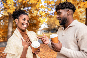 African American Couple Walking with Coffee in Autumn Park
