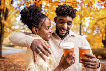 African American Couple Walking with Coffee in Autumn Park