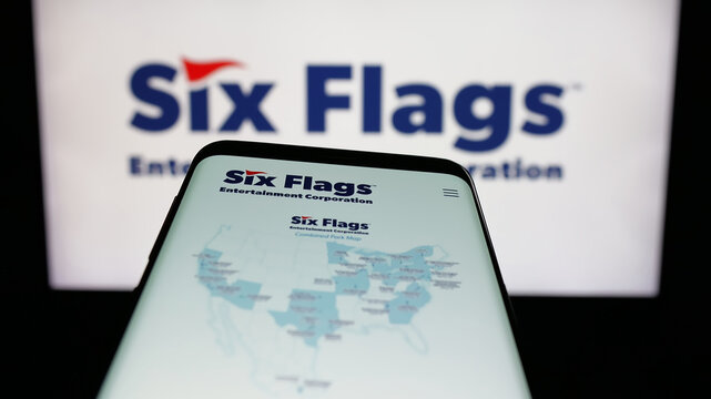 Stuttgart, Germany - 12-19-2025: Mobile phone with website of company Six Flags Entertainment Corporation on screen in front of logo. Focus on top-left of phone display.