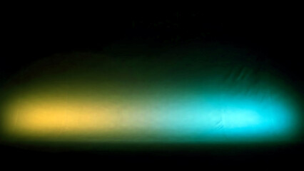 Yellow and blue gradient light effect on a dark surface creating a vibrant colorful display of light and shadow