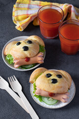 Fun food for kids - two sandwiches in shape of dog with cucumber, sausages and tomato juice