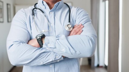 Confident Doctor in Light Blue Shirt with Stethoscope Crosses Arms, Ready to Help