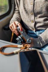 Close-up of a girl holding a film camera and about to take a picture. Train journey.