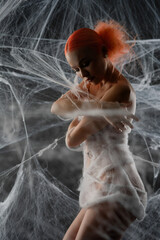 Red-haired woman caught in an intricate net trap surrounded by webs