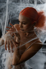 Red-haired woman entangled in a net trap amid a dramatic backdrop