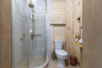 Bright rustic bathroom interior with glass shower and wooden walls