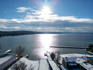 view of the port of starnberger see in bavaria germany winter landscape	and sunset
