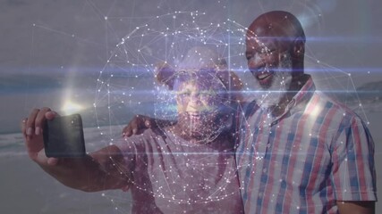 Man holding smartphone and woman on beach initiating selfie while technology grid mapping faces - Powered by Adobe