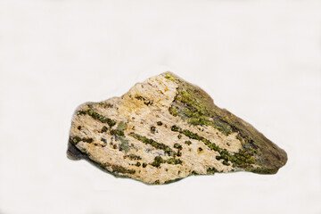 A demantond with beautiful green flecks on a light background. Gems, mineralogy, jewelry.