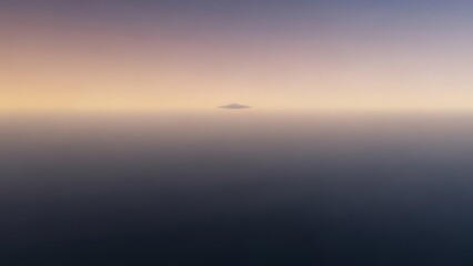 Distant island silhouetted against a gradient sunset sky over a calm, dark body of water