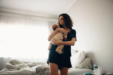 Mother holding baby in bedroom