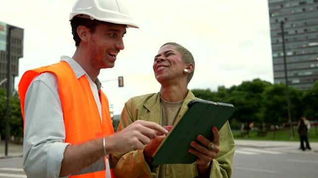 Architect and construction engineer collaborating on tablet outdoors