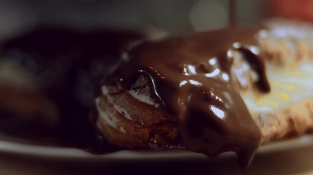 Melted chocolate is poured over the eclairs