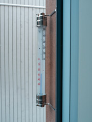 thermometer with Celsius units scale on window outdoors (-26 degrees)
