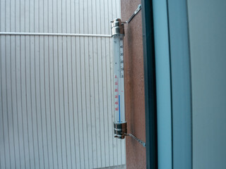 thermometer with Celsius units scale on window outdoors (-26 degrees)