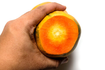 hand holding, back of a cut papaya isolated on white background