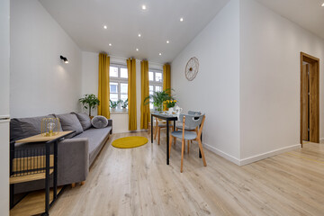 Salon w nowoczesnym apartamencie z szarą sofą i musztardowymi zasłonami © arteffect.pl