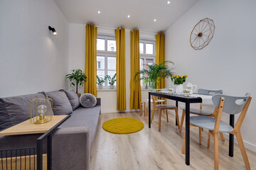 Salon w nowoczesnym apartamencie z szarą sofą i musztardowymi zasłonami © arteffect.pl