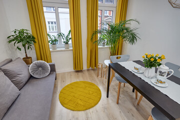 Salon w nowoczesnym apartamencie z szarą sofą i musztardowymi zasłonami © arteffect.pl