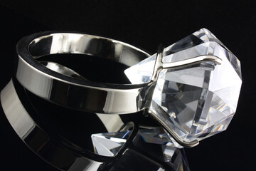 Large diamond ring paper weight on black background