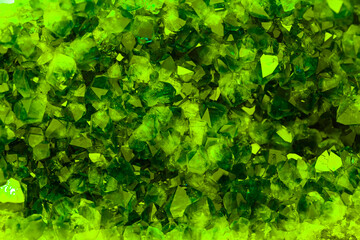 Green crystal mineral stone. Gems. Mineral crystals in the natural environment. Texture of precious and semiprecious stones. Seamless background with copy space colored shiny surface of precious stone