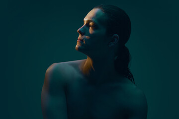 Male profile portrait with lifted chin on dark background. Concept of self perception themes, aesthetic evaluation visuals, cosmetic consultation materials, and modern beauty communication.