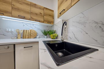 Kuchnia w nowoczesnym apartamencie &ndash; widok z poziomu blatu kuchennego na kran