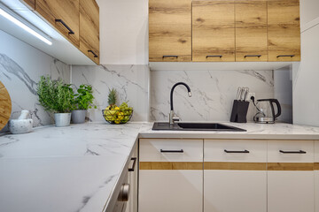 Kuchnia w nowoczesnym apartamencie &ndash; widok z poziomu blatu kuchennego na kran