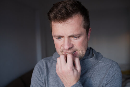 Worried male person having a bad habit, concept of mental health problems or business failure.