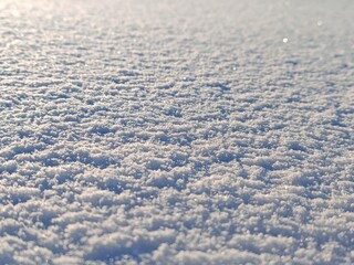 Blurred sparkling snow surface abstract. Soft defocused white snow texture with sunlight bokeh and...