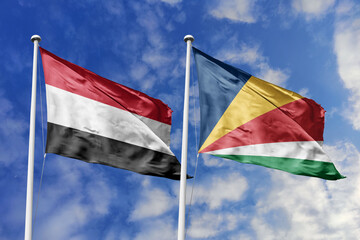 Waving flags of the Yemen and Seychelles together on blue sky background. Official diplomatic relations, partnership and business concept.
