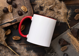 White accented coffee mug with red handle mockup on brown wood near natural decor top view