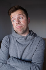 Uncertain male person looking up with hesitation, thinking or feeling skeptical.