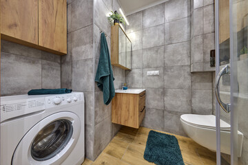 Łazienka w kawalerce z kabiną prysznicową w stonowanych kolorach