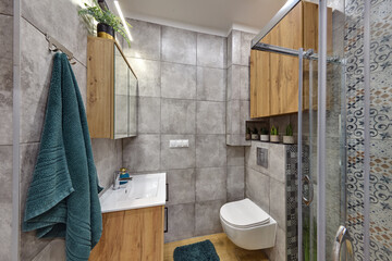 Łazienka w kawalerce z kabiną prysznicową w stonowanych kolorach