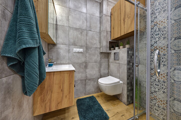 Łazienka w kawalerce z kabiną prysznicową w stonowanych kolorach