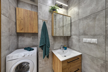 Łazienka w kawalerce z kabiną prysznicową w stonowanych kolorach