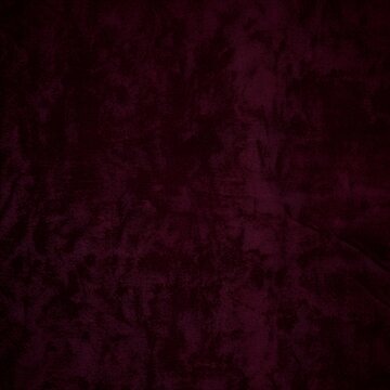 Burgundy velvet texture with mottled surface and soft tactile finish for fashion and interior design